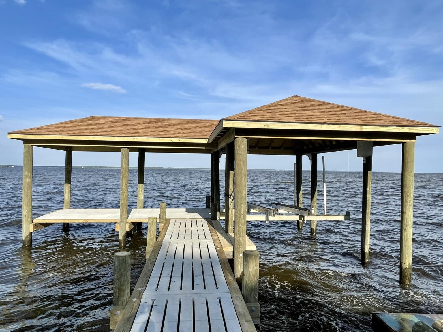 covered boathouse with boat lift on the neuse river. Bobby Cahoon Marine Construction