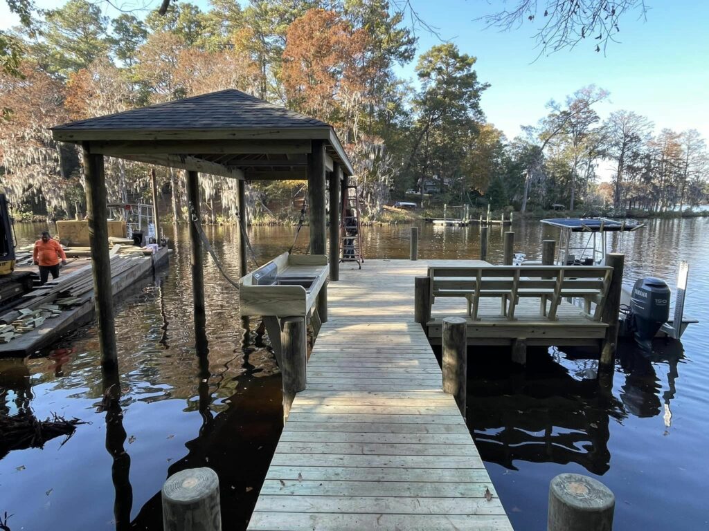 Wooden dock on Brice's Creek with gazebo, boat lift, boat slip, bench, and cleaning station. Bobby Cahoon Marine Construction