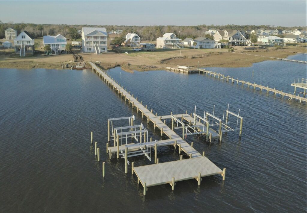 drone view of completed dock and boat slips, coastal homes in background. Bobby Cahoon Marine Construction