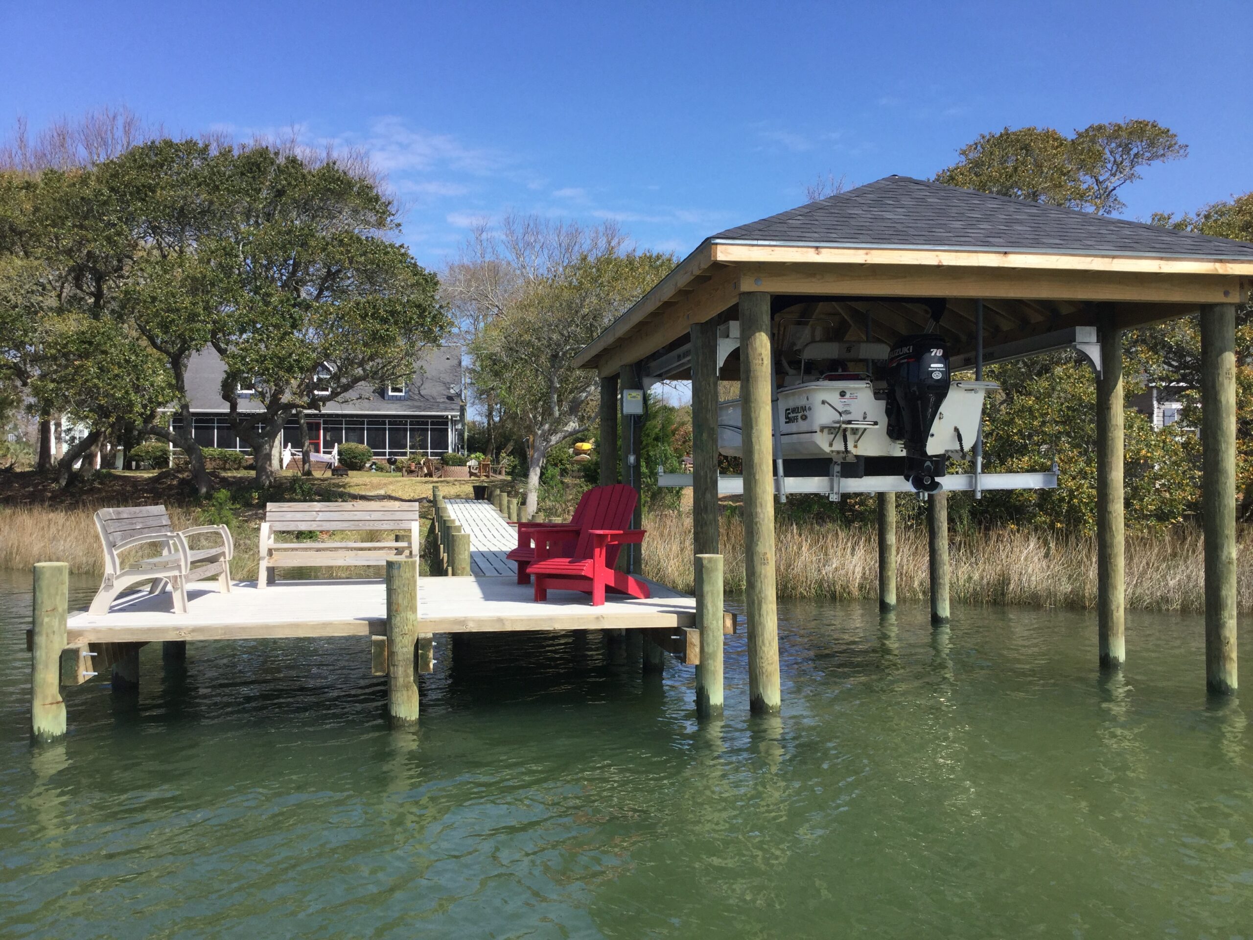Concrete dock with boathouse roof and lift in Cedar Point, Eastern North Carolina, built by Bobby Cahoon Marine Construction, the best marine contractor in Eastern North Carolina